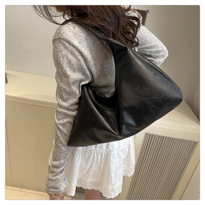 Close-up of black tote bag showing its large capacity and soft faux leather texture