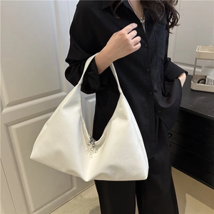 White minimalist tote bag with silver zippers shown in a stylish minimalist interior setting