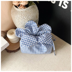 Detail of blue and white checkered drawstring bucket bag with textured cotton fabric