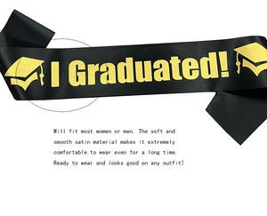 Detail of black satin graduation sash with shiny gold glitter I Graduated lettering