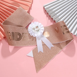 Detail of rose gold glitter Bride to Be sash and white ribbon badge for bridal shower