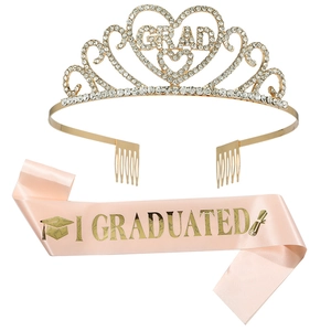 Close-up of pink satin sash with gold lettering and rhinestone graduation crown