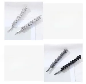 Détail de barrettes à strass marquise en finitions argent et noir fusil