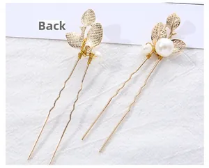 Detail of golden metal leaf hair pins with pearls showing front and back view