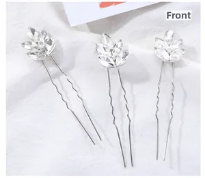 Lot de trois épingles à cheveux argentées avec feuilles en cristal sur tissu blanc