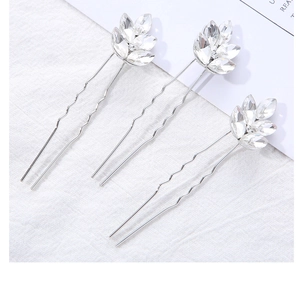 Détail de trois épingles à cheveux de mariée argentées avec cristaux en forme de feuilles
