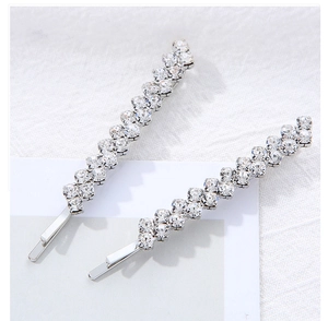 Vue détaillée de deux barrettes de mariée argentées avec des rangées de cristaux brillants