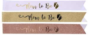 Close-up of three glitter fabric Mom to Be sashes in purple, gold and rose gold colors