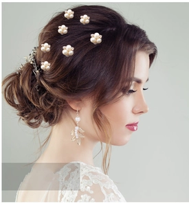 Détail des épingles à cheveux en perles et boucles d'oreilles feuilles de mariée