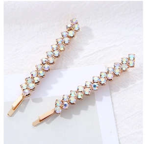 Détail des barrettes à cheveux ondulées dorées avec des strass AB colorés scintillants