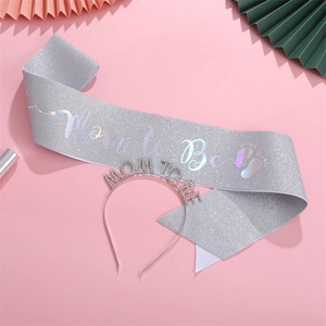 Detail of silver glitter Mom to Be sash and rhinestone headband for baby showers