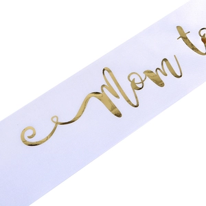 Detailansicht der weißen Satinschärpe mit eleganter Mom to be Goldfolienprägung