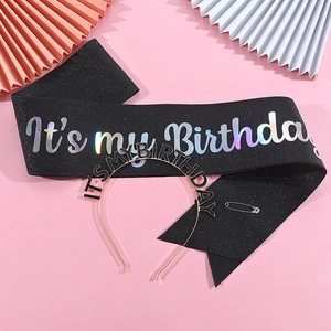 Close-up of black glitter birthday sash and gold crown headband party accessories set