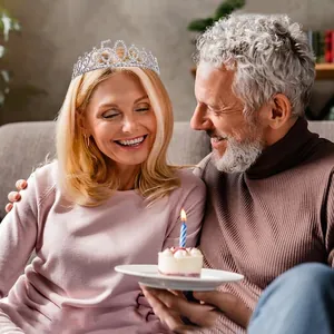 Elegant silver 50th birthday tiara with rhinestones worn by a smiling woman at a party