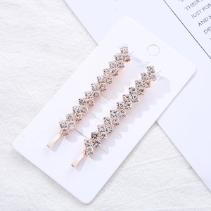 Paire de barrettes élégantes en or rose serties de strass sur carte de présentation