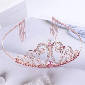 Rose gold crown headband with pink heart crystals and side combs on a grey background