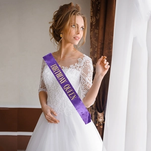 Détail d'une écharpe en satin violet avec lettrage doré Birthday Queen pour fêtes