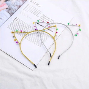 Détail d'un serre-tête oreilles de chat de Noël avec clochettes colorées et paillettes