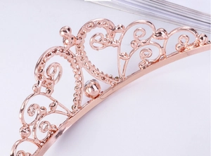 Détail de la couronne en alliage or rose avec motifs filigranes et cristaux brillants
