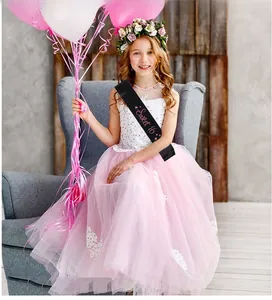 Détail de l'écharpe Sweet 16 en satin noir avec écriture rose et robe en tulle