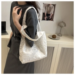 Detailed shot of white floral lace tote bag featuring intricate semi-transparent patterns