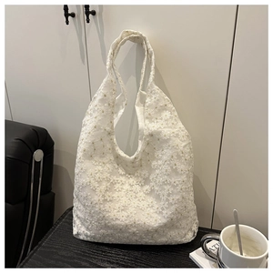 Detail of white floral lace embroidery on a summer tote bag with a soft texture