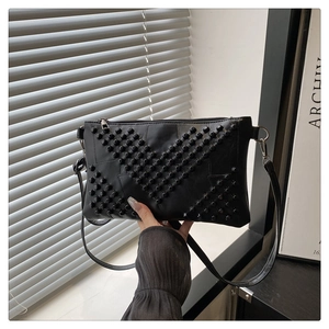 Detail of black matte PU leather bag with V-shaped rivet studs and silver zipper
