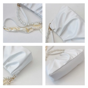 Close-up of pleated white cloud bag with pearl chain strap and silk scarf details