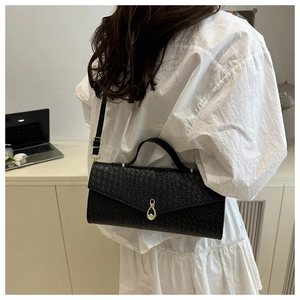 Détail du sac bandoulière noir gaufré avec fermoir goutte doré et poignée chic