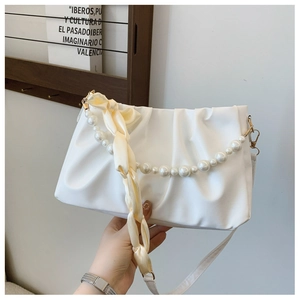 Détail du sac nuage plissé blanc avec poignée en perles et ruban de soie décoratif