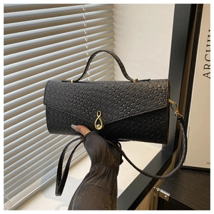 Détail du sac à main noir à texture tissée avec fermoir pivotant doré en forme de goutte