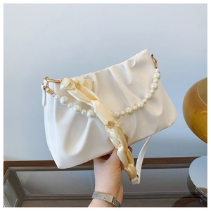 Détail du sac nuage blanc plissé avec chaîne en perles et poignée en foulard de soie chic