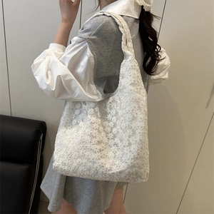 Elegant white lace tote bag with floral embroidery and pearl accents on female model