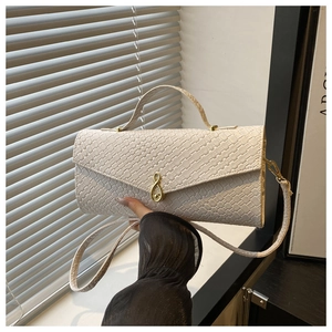 Détail d'un sac à main tissé blanc cassé avec un fermoir en métal doré infini
