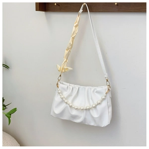 Detail of white pleated cloud bag with pearl chain and yellow silk scarf handle