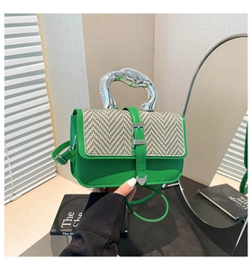 Détail du sac en cuir vert avec poignée en métal argenté et rabat en tissu tissé