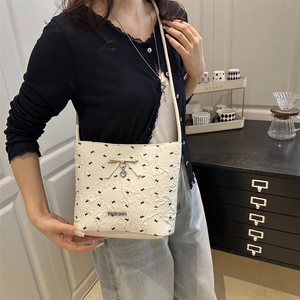 Secchiello crema alla moda con stampa di uccelli, fiocco e pendente a cuore su modella