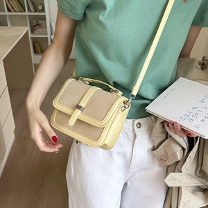 Minimalist beige woven canvas and yellow leather crossbody bag styled on a female model
