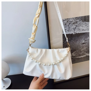Detail of white ruched bag with large pearl chain and woven shoulder strap