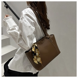 Detail der dunkelbraunen Leder-Tote-Bag mit elegantem Deko-Seidenschal am Taschengriff