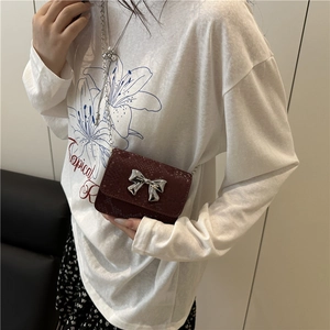 Burgundy snakeskin mini crossbody bag with a silver metal bow and chain strap