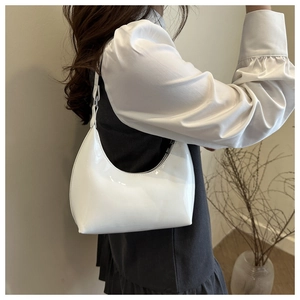 Primo piano della superficie in vernice bianca lucida e forma hobo della borsa a spalla