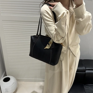 Minimalistische schwarze Shopper-Tasche mit dekorativem Seidenschal am Taschengriff