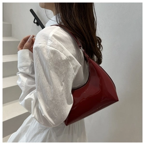 Dettaglio della borsa hobo in pelle verniciata bordeaux con finitura lucida e cerniera