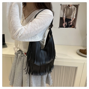 Vista de detalle del bolso de hombro negro con flecos estilo hobo para mujer