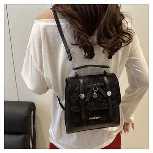 Rear view of a black backpack with bow detail and floral texture on a female model