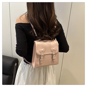 Close-up of pink PU leather backpack with sweet bow accents and silver buckle details