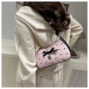 Vue détaillée du sac rose à fleurs avec des nœuds noirs et un pendentif en cœur