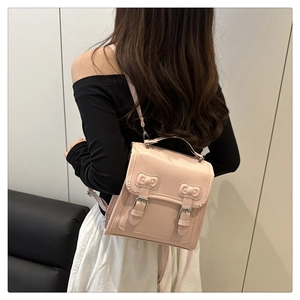 Gros plan du mini sac à dos rose avec boucles métalliques et coutures décoratives en nœud