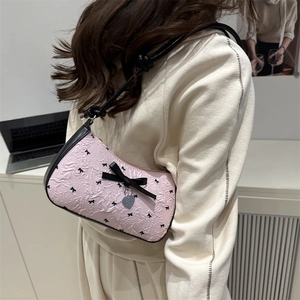 Sac sous le bras rose en seersucker avec nœuds noirs et pendentif cœur sur modèle